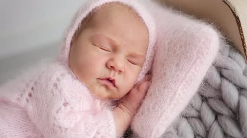 Peaceful Newborn Baby Sleeping Soundly in Knitted Outfit