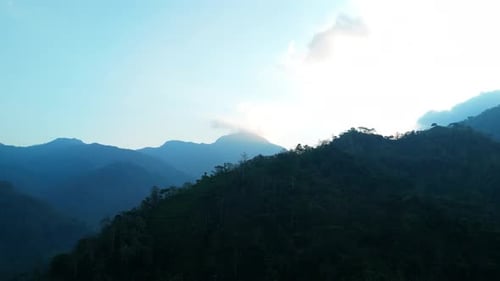 Aerial view from top of green mountain with cloudy morning sky