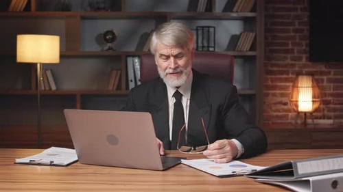 Man With Beard Points To Camera In Office