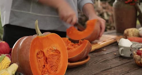 Woman Preparing Pumpkin on Rustic Wooden Table