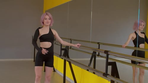 Graceful Attractive Female Ballet Dancer Rehearsing at Barre in Dance Studio
