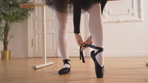 Ballerina Puts on Pointe Shoes on Leg in Dance Class Classical Ballet Dancer Woman in Dance Studio