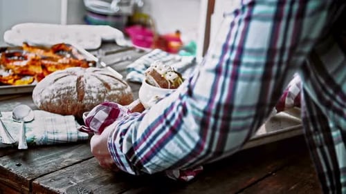 Placing a Tray of Hearty Cheesy Soups on a Rustic Wooden Table