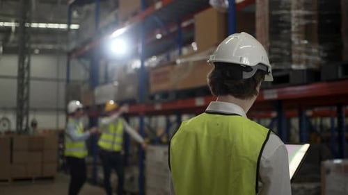 Blue collar workers are working at warehouse.