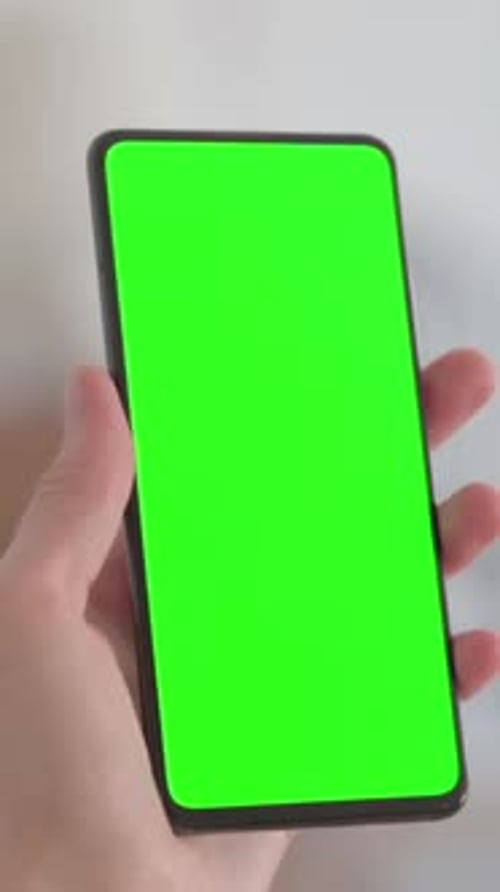 Close Up of Female Hand using Smartphone with Green Screen, vertical video