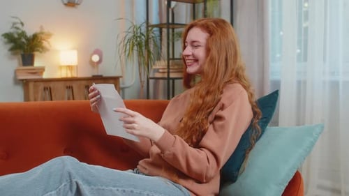 Woman Receives Exciting News at Home on Couch