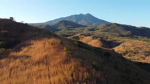 Scenic Aerial View of Dry Grass Hills and Distant Mountain