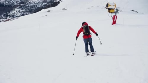 Skier skiing down the slope making turns in slow motion