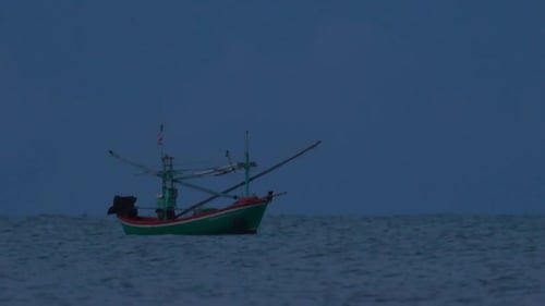 Fishing Boats in Thailand wait in the middle of the ocean for dark to come so they can turn on their