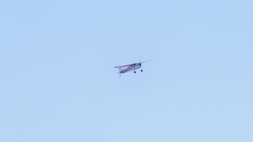Distant View of Generic Small Private Single Engine Airplane Flying in Blue Sky
