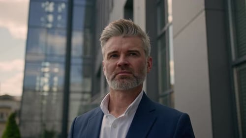 Handsome Man in Blazer Stands in Front of Building