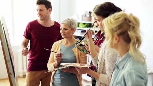People painting together in art class, happy expressions