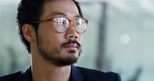 4k video footage of a handsome young businessman looking thoughtful in an office