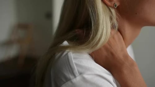 Woman Rubs Her Neck in Close Up