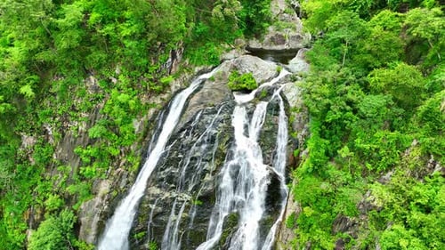 Beautiful waterfall in the green tropical forest. Drone aerial view.
