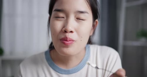 Woman Eating Food from Spoon, Close Up