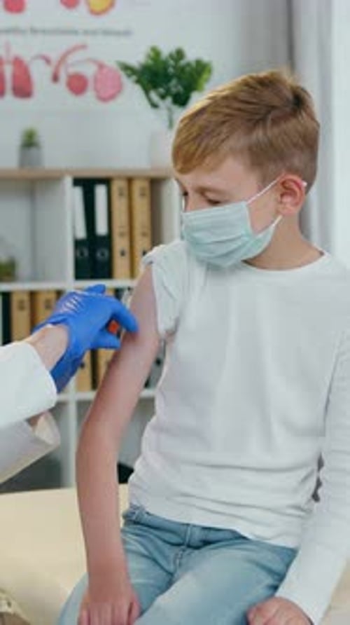 Boy Receiving Vaccine from Doctor in Clinic