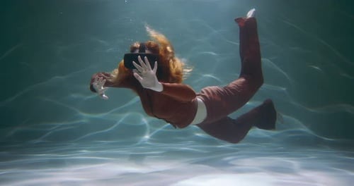 Beautiful Young Woman in Virtual Reality Headset Glasses Floating Under Water Touching Invisible