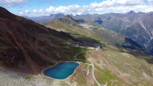 Aerial footage from a mountain lake in the Austrian Alps on a sunny summer days with only a few fluf
