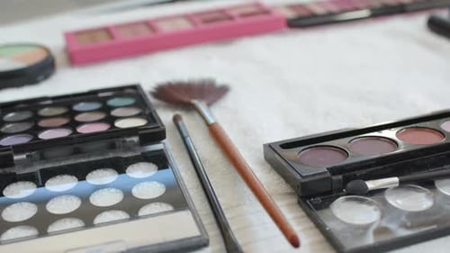 Makeup palettes and brushes arranged on table for beauty routine at home