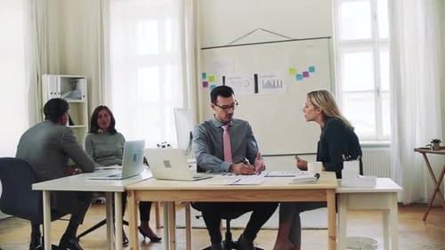 Diverse business team collaborating on laptop project in modern office space