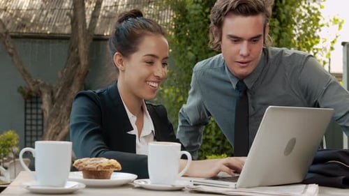 Colleagues Working Together on a Laptop at Cafe
