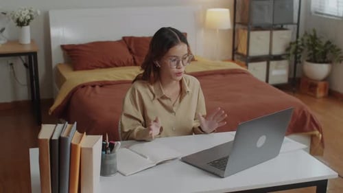 Woman Using Laptop for Video Call in Bedroom