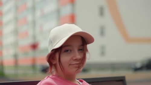 Casual Youth Sitting With Playful City Scenery Behind Selfassured Teenager Leaning On Bench In City