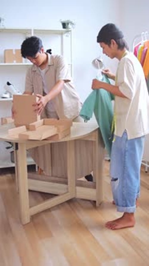 Two young entrepreneurs preparing clothing orders for shipment to customers