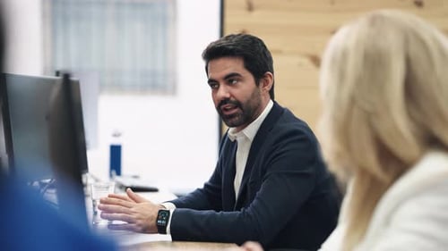 Business Meeting in Office with Man Speaking to Coworkers