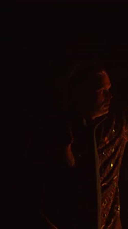 Man Sings in the Darkness with Hair Braids