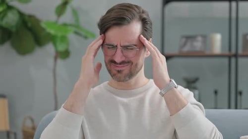 Man Rubs Temples in Painful Headache