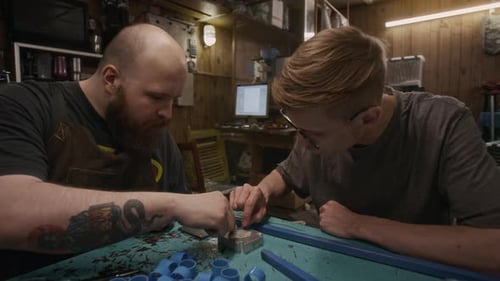 Deux technologues masculins discutant du moule d'extrusion en plastique dans un atelier