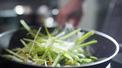 Sizzling Green Vegetables Stir Frying in a Hot Pan with Steam