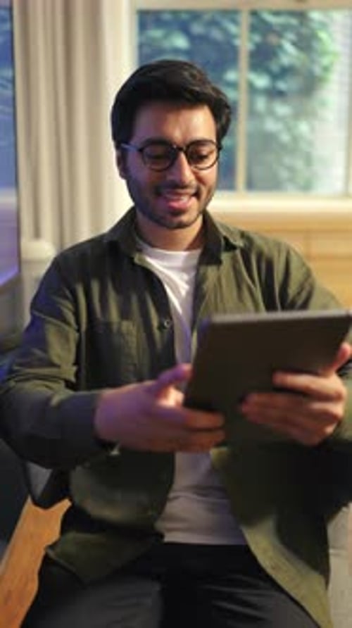 Young Man Using Digital Tablet While Working Remotely in Modern Interior