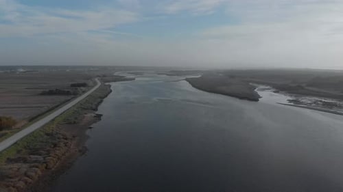 Luftbild des schönen Flusses Seite an Seite mit dem Meer und den Getreidefeldern.