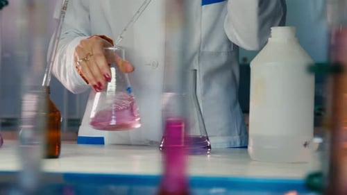 Scientist mixing colorful chemicals in laboratory