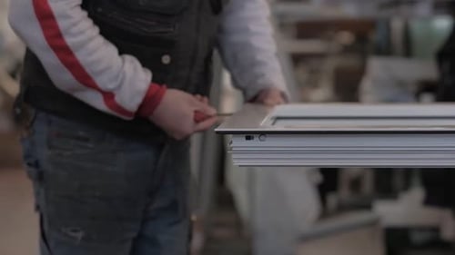 Worker smoothing edges of a white window frame