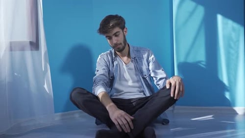 Man Sitting Cross-legged on the Floor Indoors