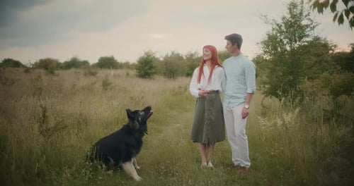 Couple Playing with German Shepherd in Autumn Park