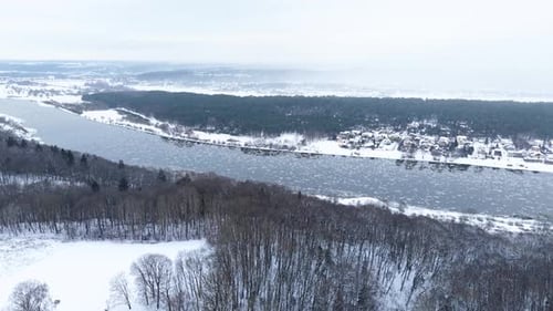 Luftaufnahme der verschneiten Wald- und Flusslandschaft im Winter