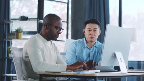 Two Business Professionals Collaborate on a Project in a Modern Office Space During Daylight