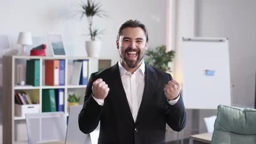 Caucasian Businessman Gesturing From Happiness at Office