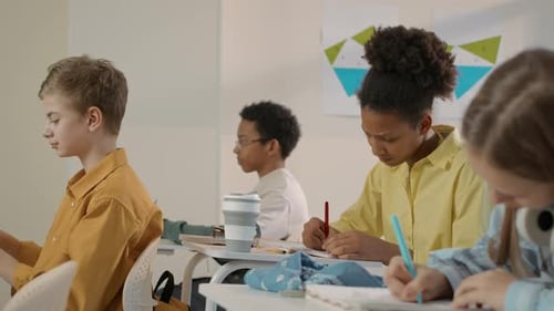Students Concentrating and Writing in Classroom Environment