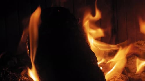 Burning Flame At Fireplace on wooden logs. Medium shot of a yule log burning in a fireplace.