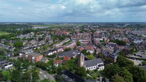 Aerial view of a charming European town with red rooftops, green trees, and historic buildings