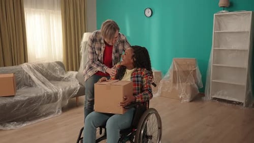 A Couple Moves Into a New Apartment The Guy Brings the African American Girl in a Wheelchair to the