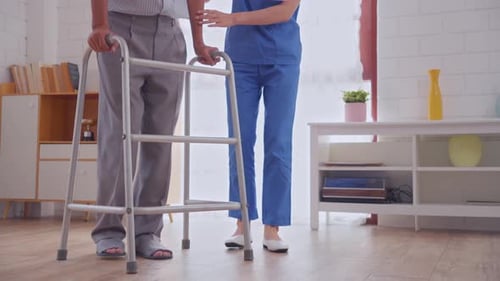 Close up feet of male patient doing physical therapy with caregiver.