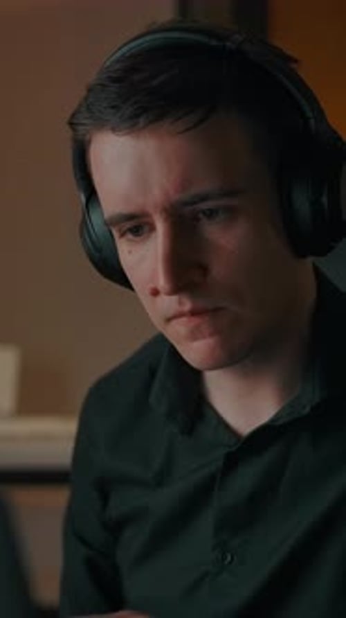 Young Adult Working on Computer with Headphones On