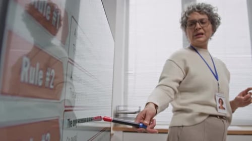 Woman Explaining Rules on Interactive Whiteboard in Classroom